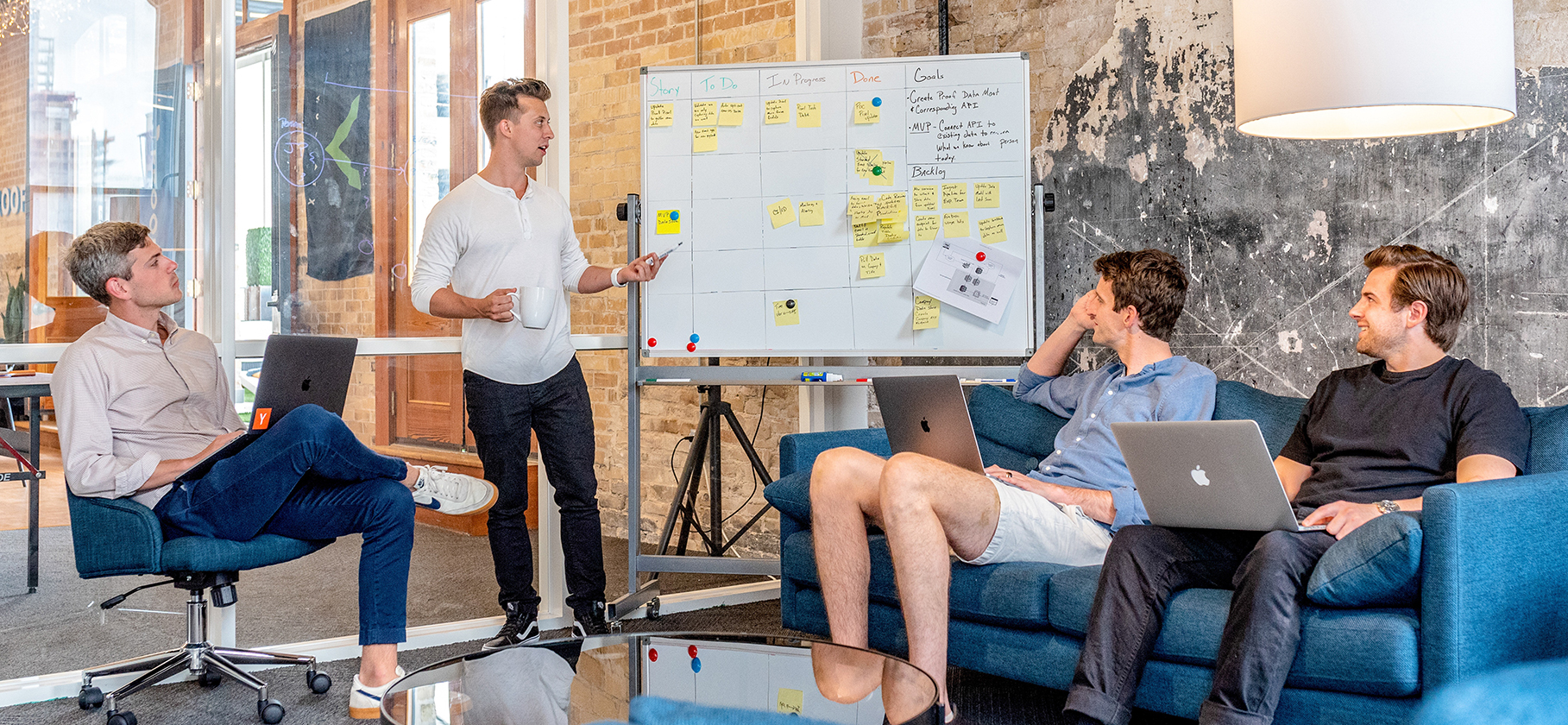 4 men in a meeting with a whiteboard