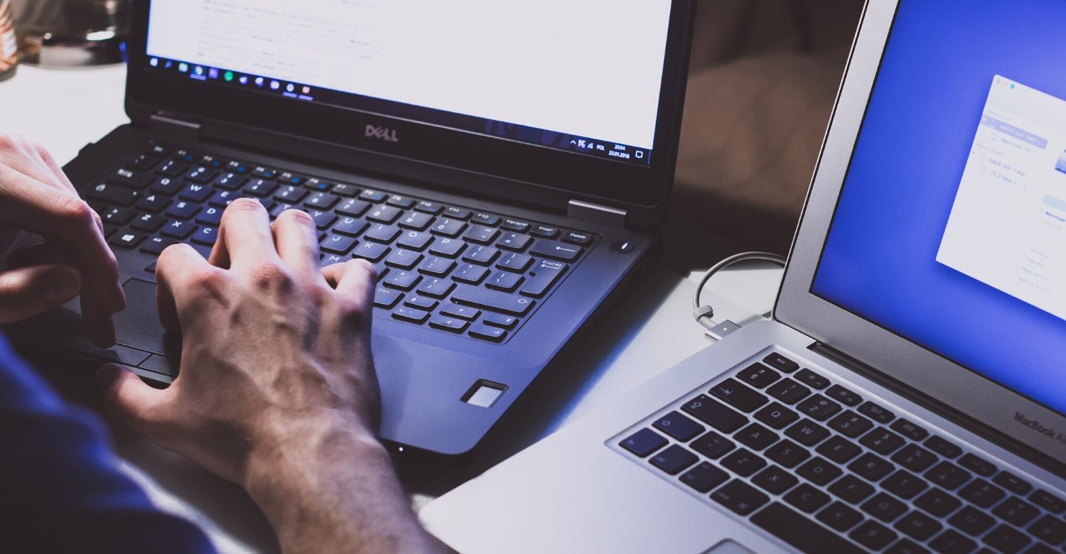 man at two different laptops