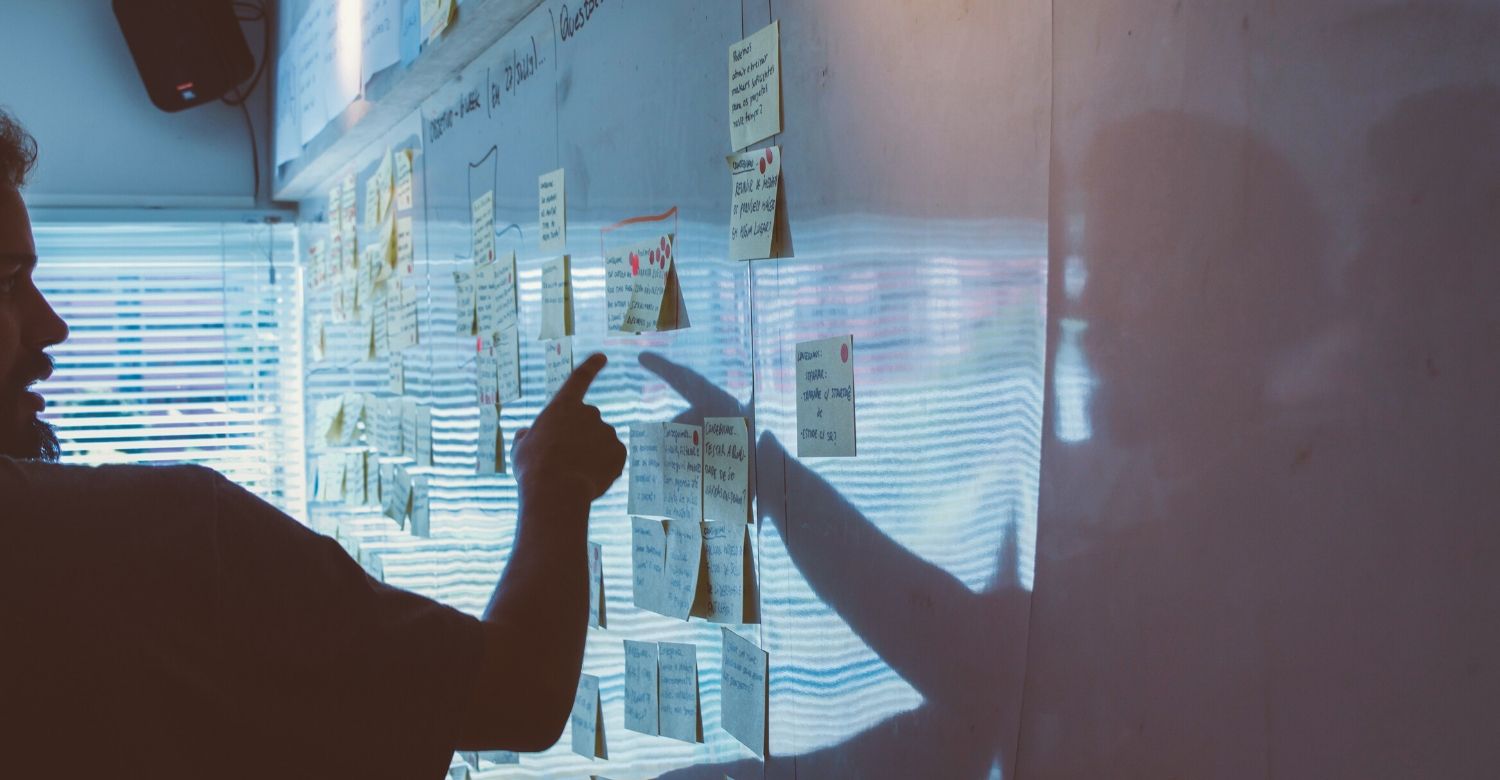 man at white board with stickies