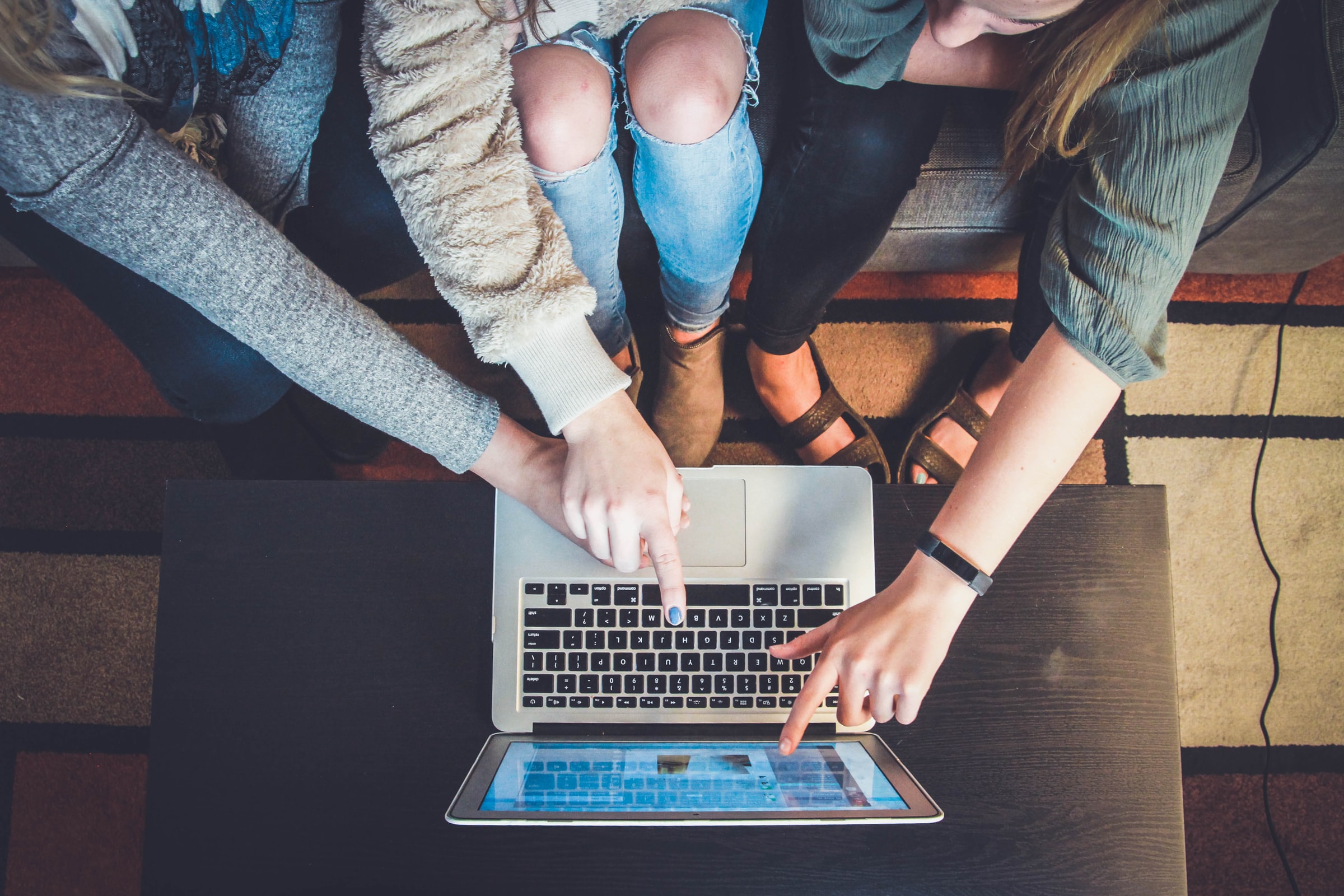 compelling offers people pointing at laptop screen